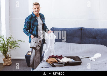 Cropped View Of Man Packing Clothes Into Travel Bag Stock Photo, Picture  and Royalty Free Image. Image 114774181.