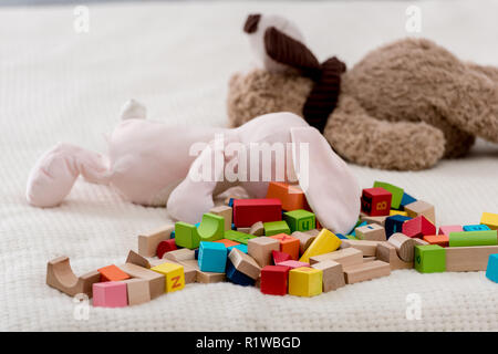 Colourful toy cubes and teddy bears lying on plaid Stock Photo