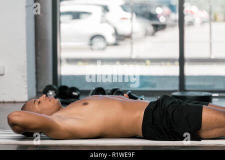 selective focus of african american sportsman resting on fitness at at gym