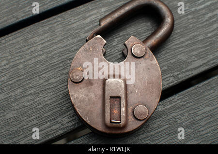 Old weathered grunge retro open padlock closeup on wooden boards background Stock Photo