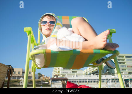 Frozen 3 years boy warming up after swimming. He has bruised lips Stock Photo