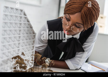 focused african american female adult architect in glasses and formal wear working on construction project Stock Photo