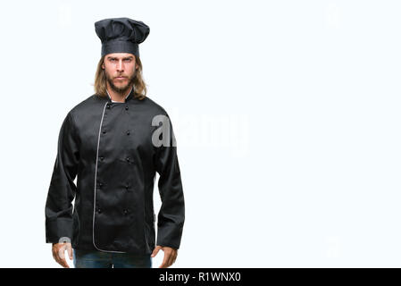 Young handsome cook man with long hair over isolated background skeptic and nervous, frowning upset because of problem. Negative person. Stock Photo