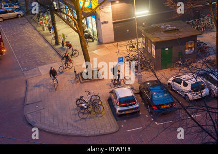 View above Amsterdam street with bicycle and cars parking illuminated in the evening, Netherlands Stock Photo