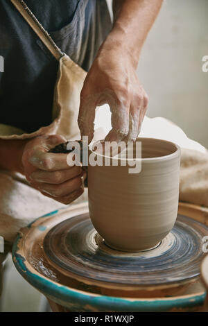 partial view of male craftsman working on potters wheel at pottery studio Stock Photo