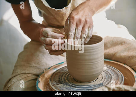 cropped image of male craftsman working on potters wheel at pottery studio Stock Photo