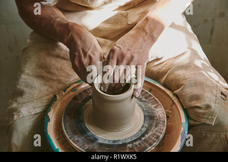 close up view of male potter hands working on pottery wheel at workshop Stock Photo