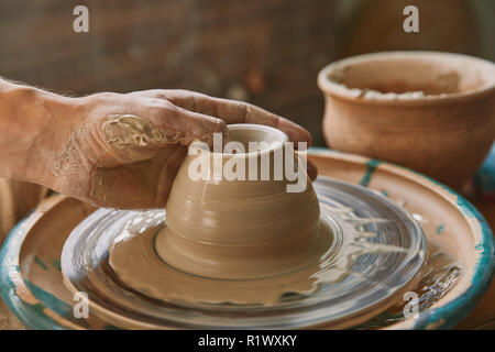 cropped image of professional potter working on pottery wheel at workshop Stock Photo