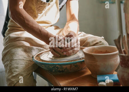 partial view of potter working on pottery wheel at workshop Stock Photo