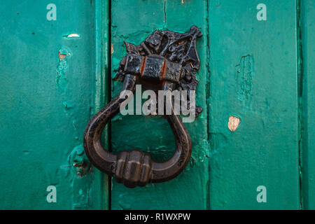 Aged church door iron handle knocker rudted - closed-up - green chipped paint Stock Photo