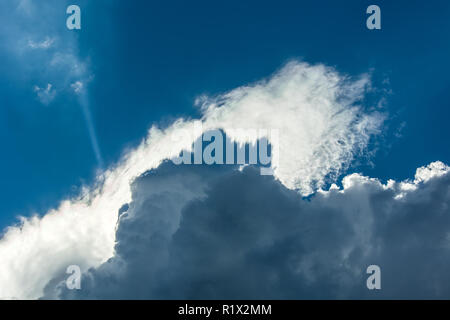 The sun is hidden behind the clouds in the sky Stock Photo