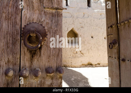 A rusting steel knocker on a timber door in an ancient desert village. Stock Photo