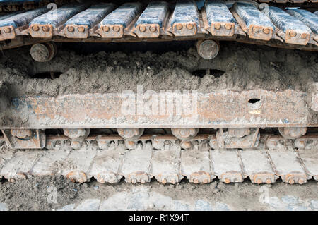 Close up of a set of synthetic rubber tracks on excavator whilst working on building site Stock Photo