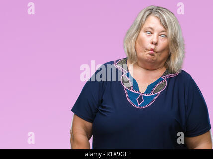 Senior plus size caucasian woman over isolated background making fish face with lips, crazy and comical gesture. Funny expression. Stock Photo