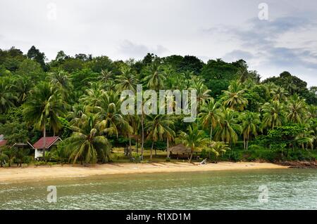 Tropical landscape with amber sand beach, rocks, coconut palm trees and turquoise tropical sea on Koh Chang Island in Thailand Stock Photo