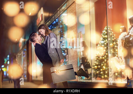 A young couple with packages is shopping  on Christmas Day.  Stock Photo