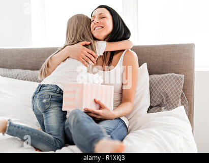 Happy mother's day. A Child daughter congratulates moms and gives her a gift Stock Photo