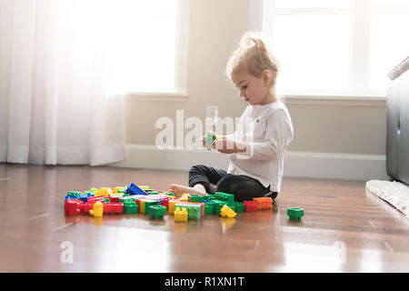 A child girl building from toy blocks at home Stock Photo