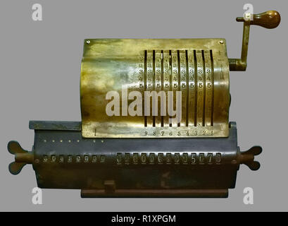 ANTIQUE ROTARY CALCULATOR. Old vintage rotary calculator on isolated grey background with clipping path. Stock Photo