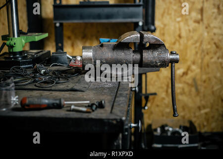 Damaged old used vise grip on blacksmith table Stock Photo