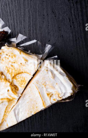 Top view image on two pieces of coconut pie isolated cut on wooden background, bakery texture, ripple pattern of soft cream Stock Photo