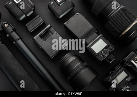 Large collection of professional and modern photographic equipment on a black background (low key). Stock Photo