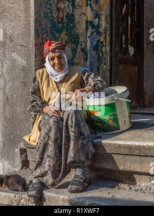 Istanbul, Turkey, November 9, 2012: Elderly Turkish lady sitting on her doorstep. Stock Photo