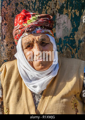 Portrait of an elderly Turkish woman with traditional bonnet sitting in ...