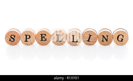 Word Spelling from circular wooden tiles with letters children toy. Concept of grammar spelled in children toy letters. Stock Photo