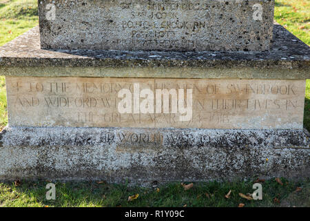 Names of soldiers on war memorial for The Great War 1914-1918 - World War I and World War II 1939-1945  alongside graves in traditional graveyard of S Stock Photo