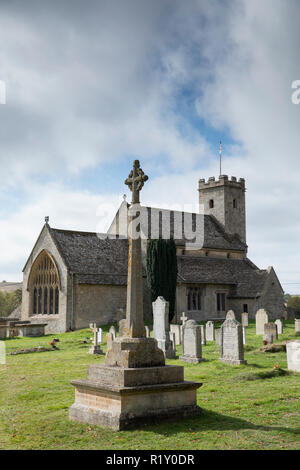 Wreaths of poppies at war memorial for The Great War 1914-1918 - World War I and World War II 1939-1945  alongside graves in traditional graveyard at  Stock Photo