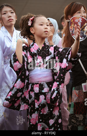 Children in kimono dress dancing to the rhythm of the folk songs in Bon Odori festival. Stock Photo