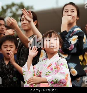 Children in kimono dress dancing to the rhythm of the folk songs in Bon Odori festival. Stock Photo