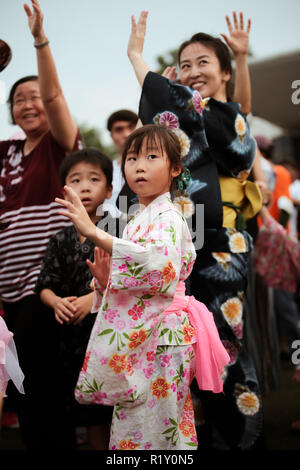 Children in kimono dress dancing to the rhythm of the folk songs in Bon Odori festival. Stock Photo