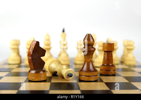 light and dark chess pieces on a chessboard on a light background Stock Photo