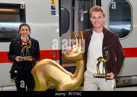 Munich, Germany. 15th November, 2018. 15 November 2018, Bavaria, München: Nico Rosberg, a former racing car driver, and a train attendant stand at Munich Central Station with a Bambi figure holding a Bambi in their hands. Rosberg accompanies the golden bambios to the media award ceremony in Berlin. Photo: Tobias Hase/dpa Credit: dpa picture alliance/Alamy Live News Stock Photo