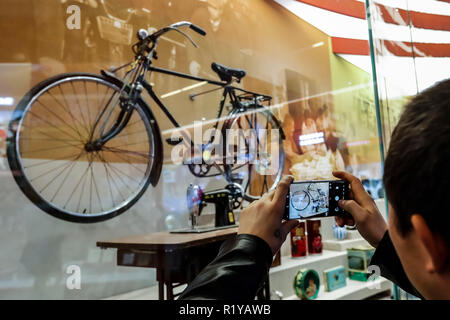 (181115) -- BEIJING, Nov. 15, 2018 (Xinhua) -- A visitor takes pictures of a vintage bike and sewing machine displayed at a major exhibition to commemorate the 40th anniversary of China's reform and opening-up at the National Museum of China in Beijing, capital of China, Nov. 15, 2018. Vintage objects are displayed at the exhibition which opened here on Tuesday to show visitors the history, accomplishments, and experience of China's reform and opening-up. (Xinhua/Shen Bohan) (lmm) Stock Photo