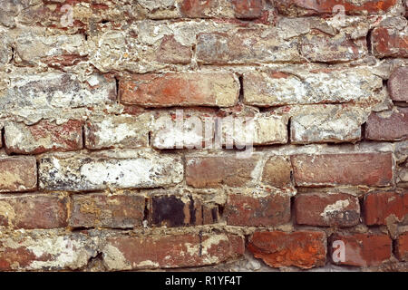 Detail of old brick wall with shelled color paint layers Stock Photo