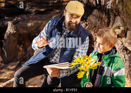 Positive nice man explaining to his son about nature Stock Photo