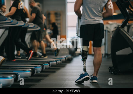cropped shot of athletic sportsman with artificial leg walking by gym Stock Photo