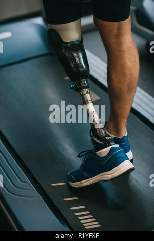 cropped shot of sportsman with artificial leg walking on treadmill at gym Stock Photo