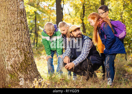 Nice positive young children looking for mushrooms Stock Photo