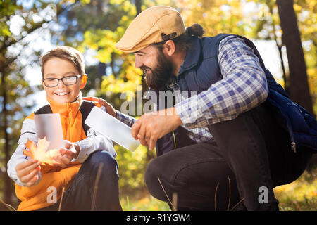 Nice positive man and his son holding smartphones Stock Photo