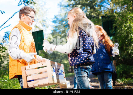 Nice blonde girl putting a bottle in the box Stock Photo