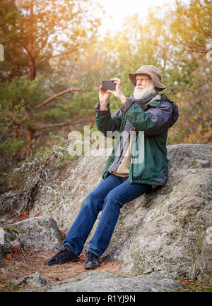 Senior man outdoors using a smartphone to take picture Stock Photo