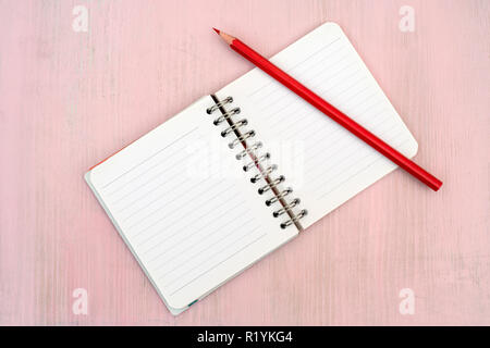 Red pencil and notebook for notes. Stock Photo