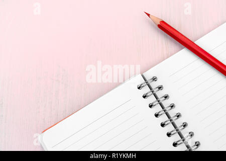 Red pencil and notebook for notes. Stock Photo