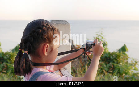 Asian girl holding camera taking a picture with travelling, smilling and happiness in natural. Stock Photo