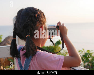 Asian girl holding camera taking a picture with travelling in nature. Stock Photo