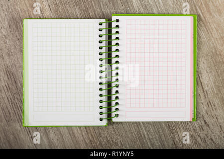 Open notebook lying on wooden surface Stock Photo